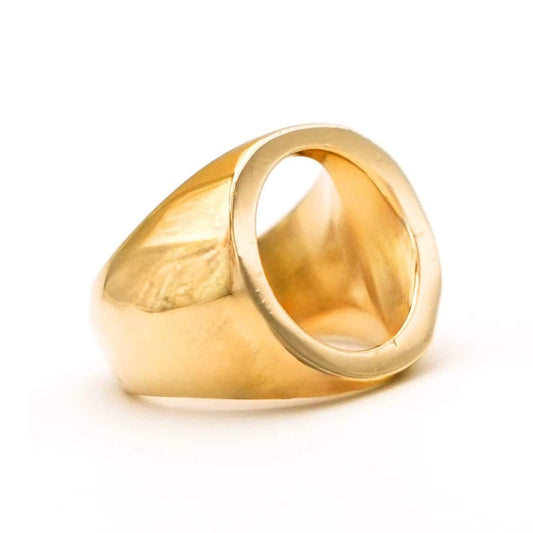 A polished yellow gold signet ring with a wide, flat face and a thick band, shown on a clean white background.