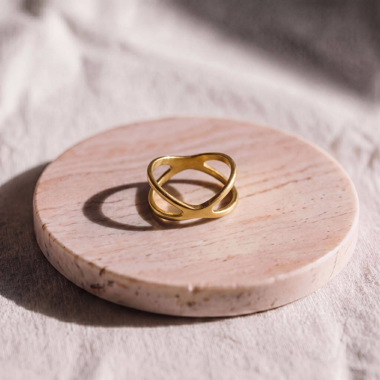 Gold ring on a round pink stone surface