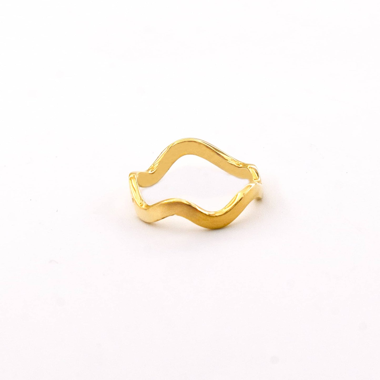 Gold ring with wavy design on a white background
