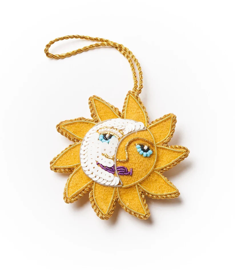 Colorful embroidered sun and moon face ornament embellished with beads and a hanging cord.