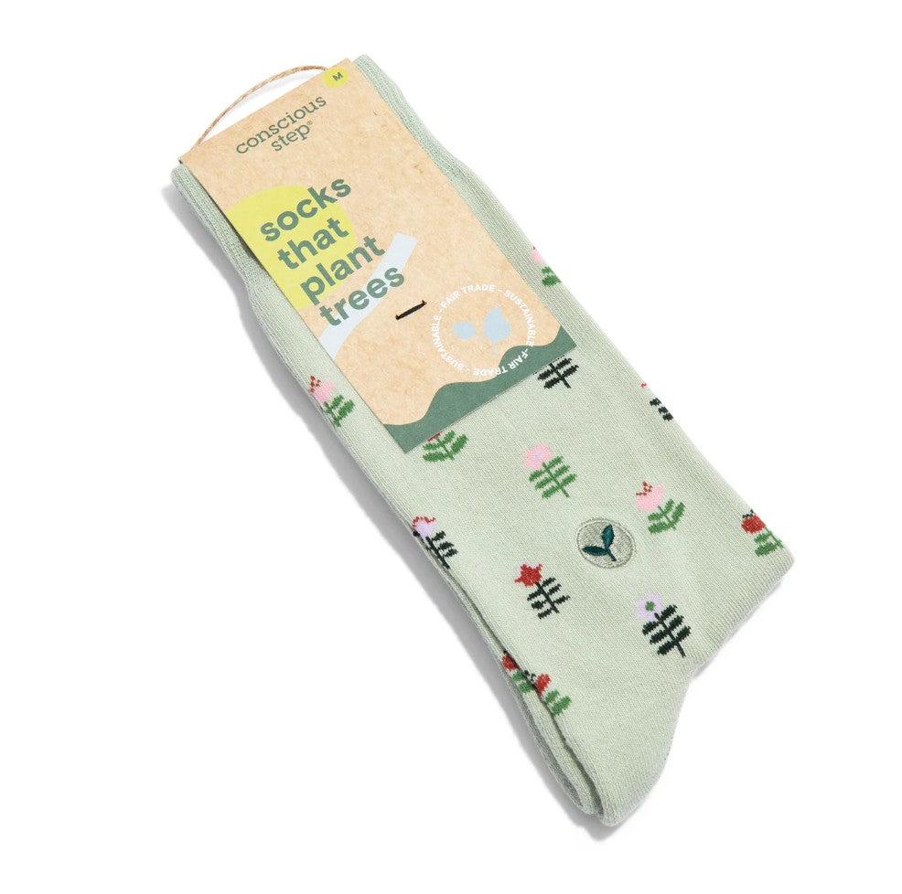 Green socks with geometric plant designs and light brown display tag laid on a white background