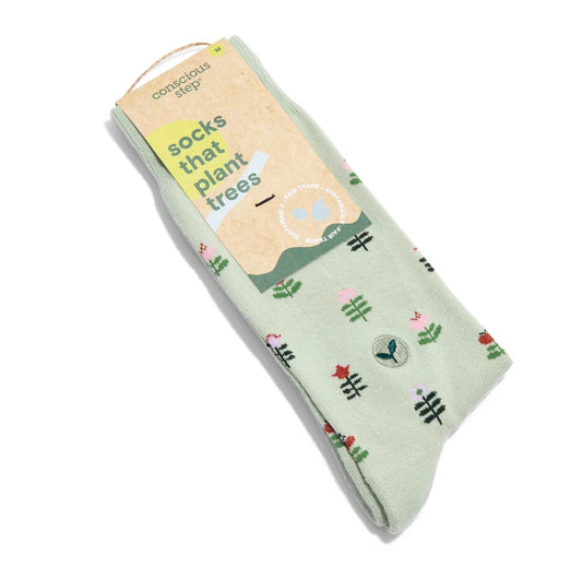Green socks with geometric plant designs and light brown display tag laid on a white background
