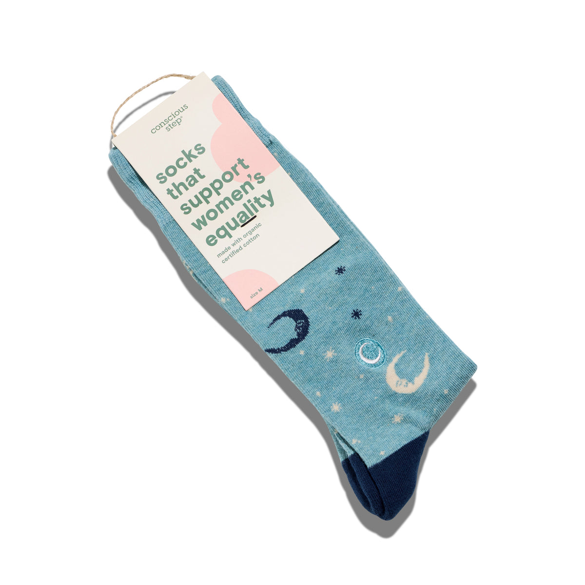 Blue socks with celestial design and a brown tag that reads "Socks that support women's equality" on a white background