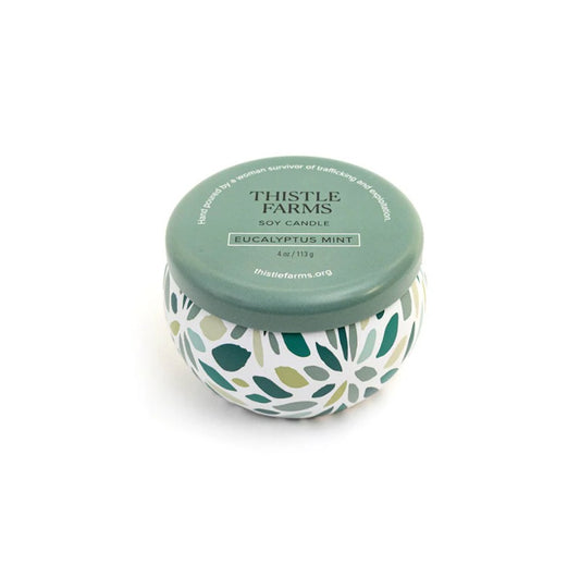 Candle jar with floral design and green lid on a white background