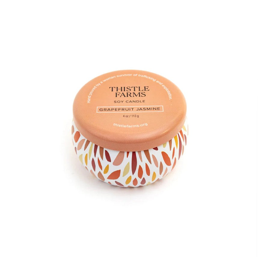 Thistle Farms soy candle with a patterned label on a white background