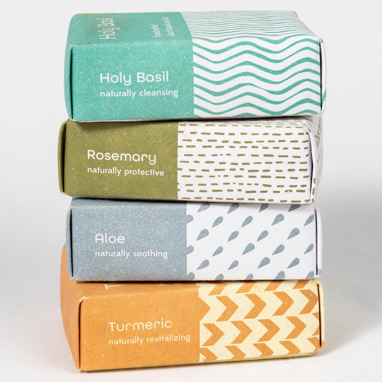 Four bars of soaps in different colored packages are stacked vertically on a white background.