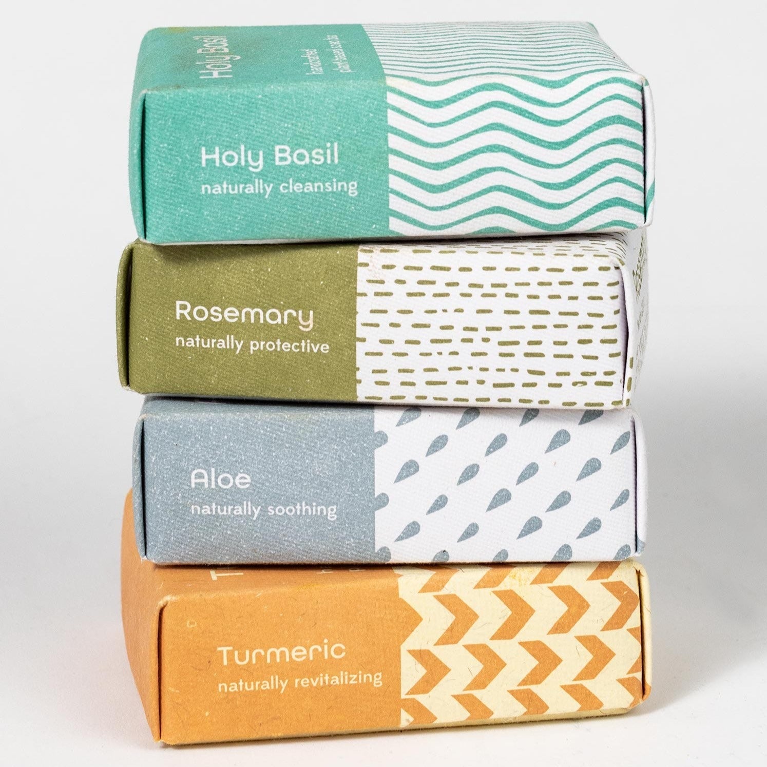 Four bars of soaps in different colored packages are stacked vertically on a white background.