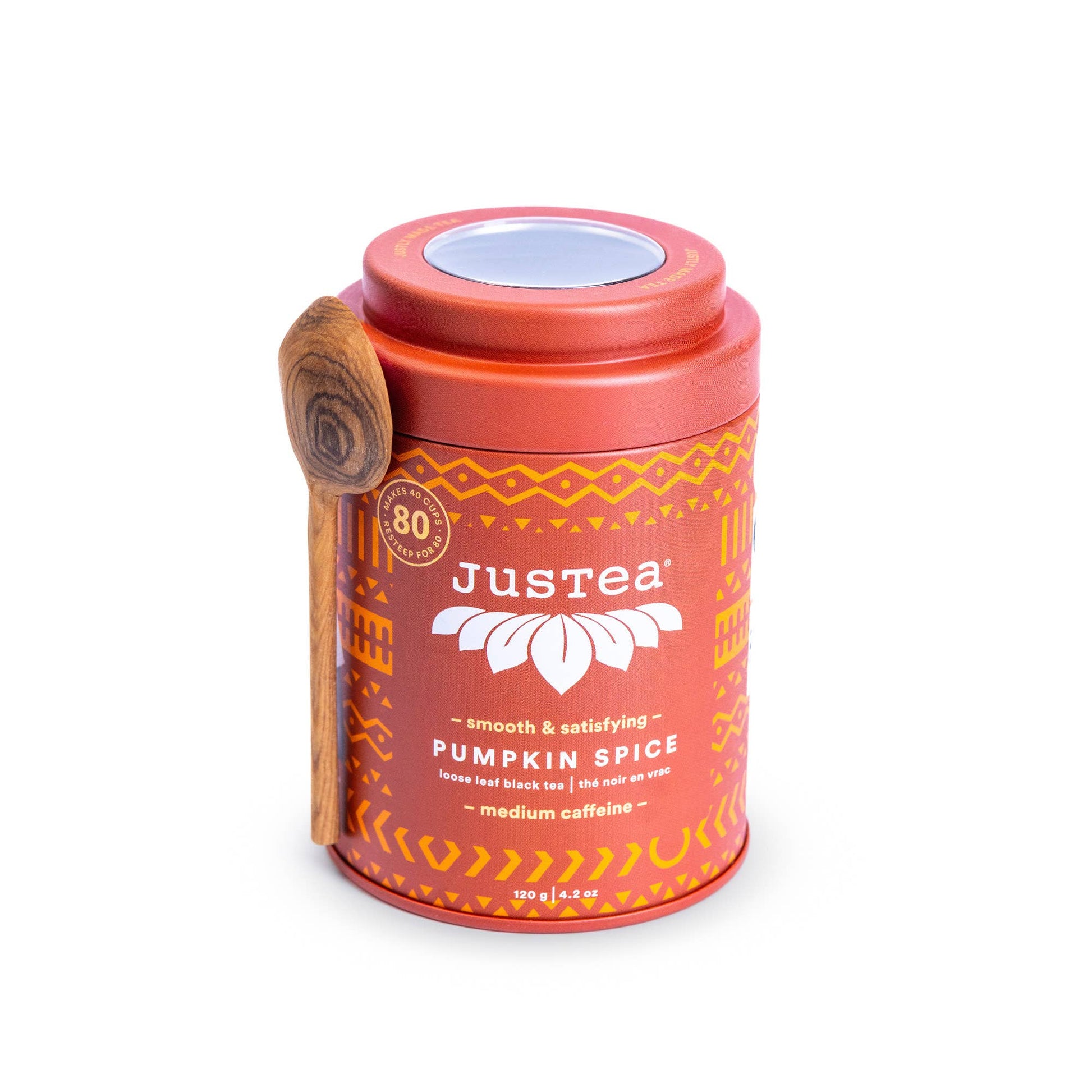 Justea pumpkin spice tea canister with a wooden spoon on a white background