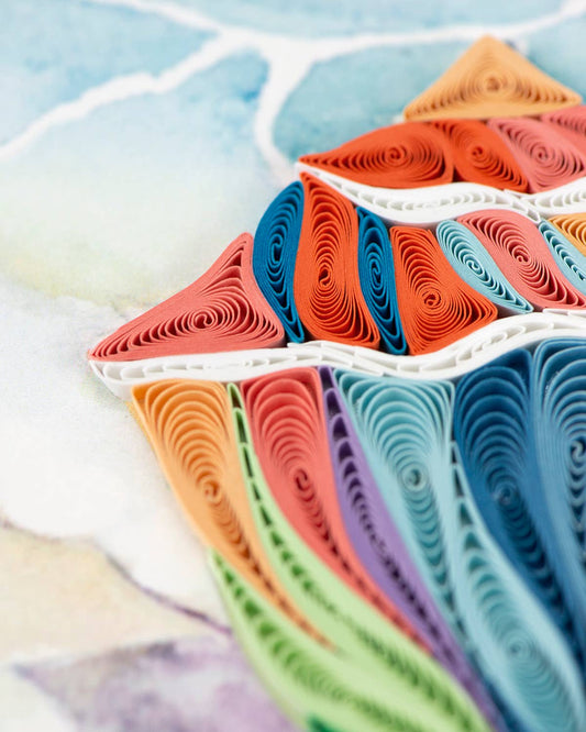 Colorful pieces of coiled paper create the top half of a conch shell design.