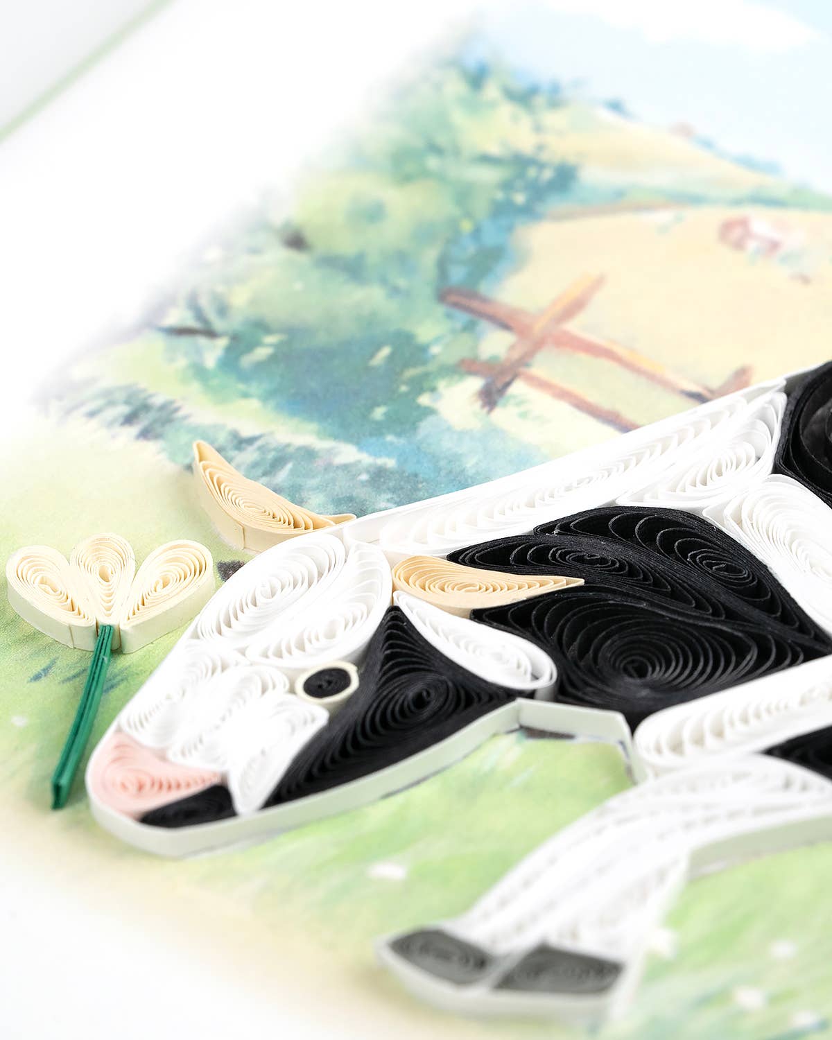 Close up of black and white quilling shapes that make up a cow's head.