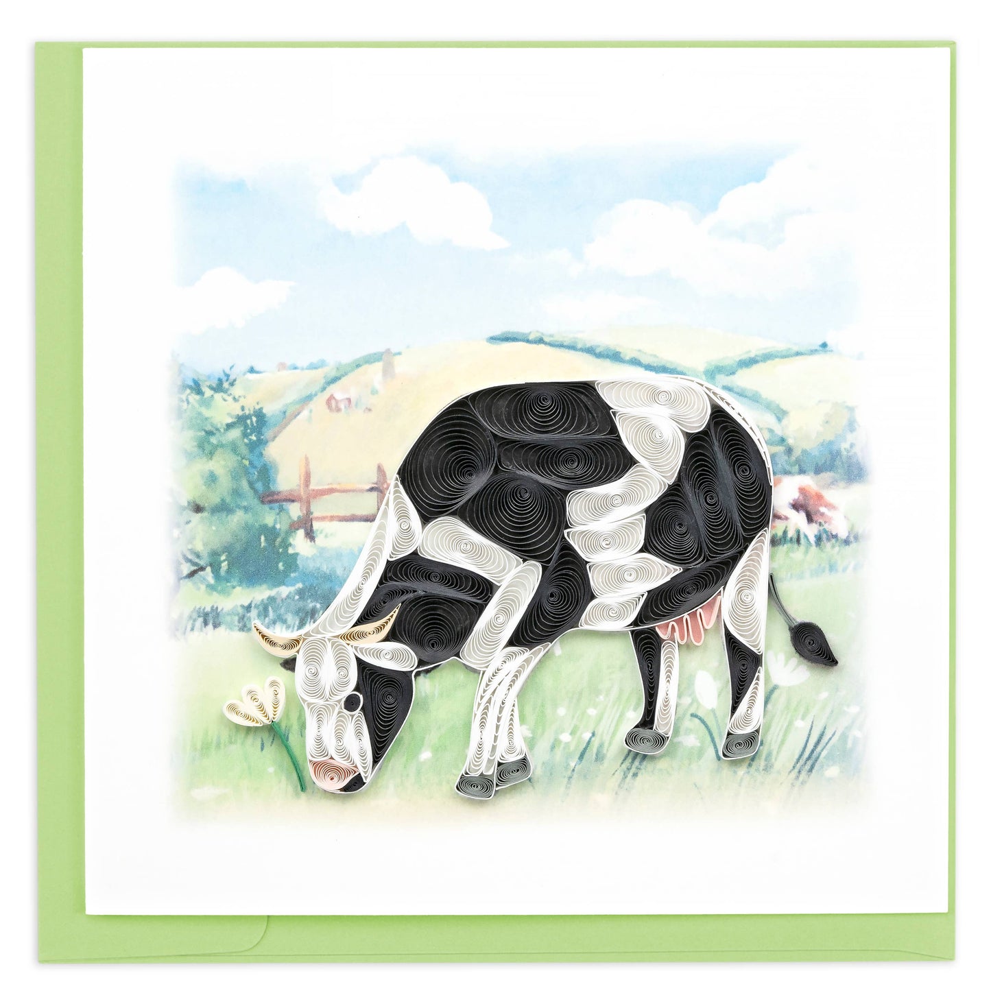 Black and white cow grazing on grass in a field.