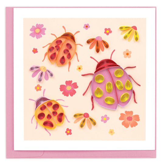 Pink and orange ladybugs are surrounded by florals and covered with quilled paper spots.