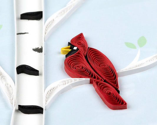Card with red cardinal bird on a branch against a light blue background