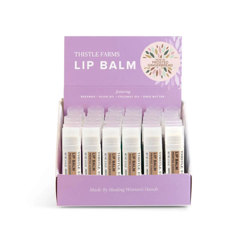Rows of White Lip balm tubes with tan decoration in a display tray on a white background