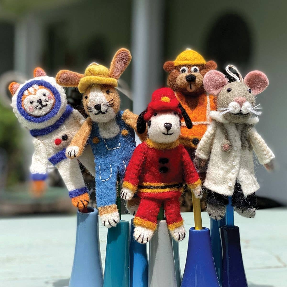 Five colorful animal puppets on stands with a blurred background