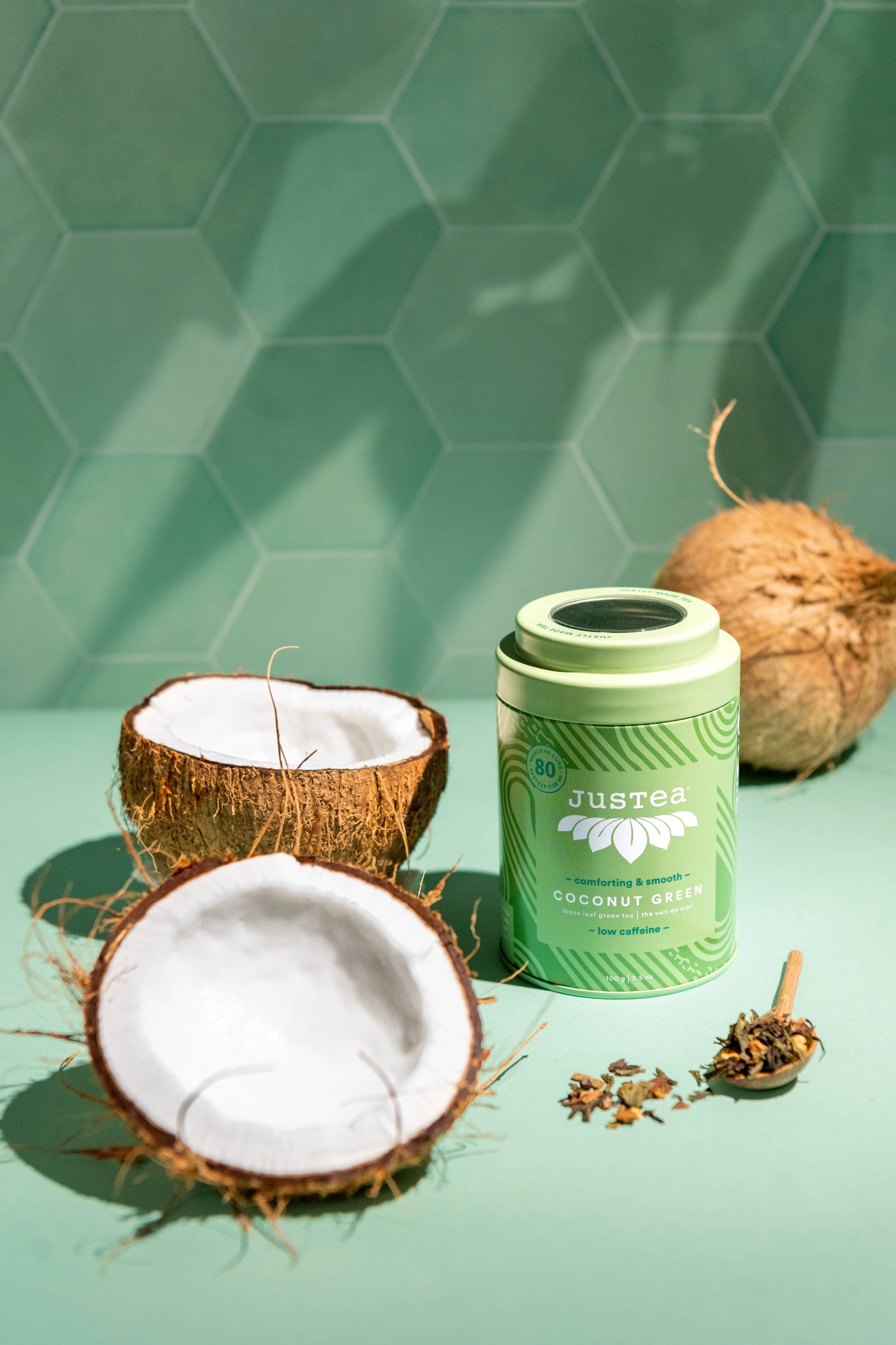Green tea tin labeled 'Justea' with coconuts on a green background