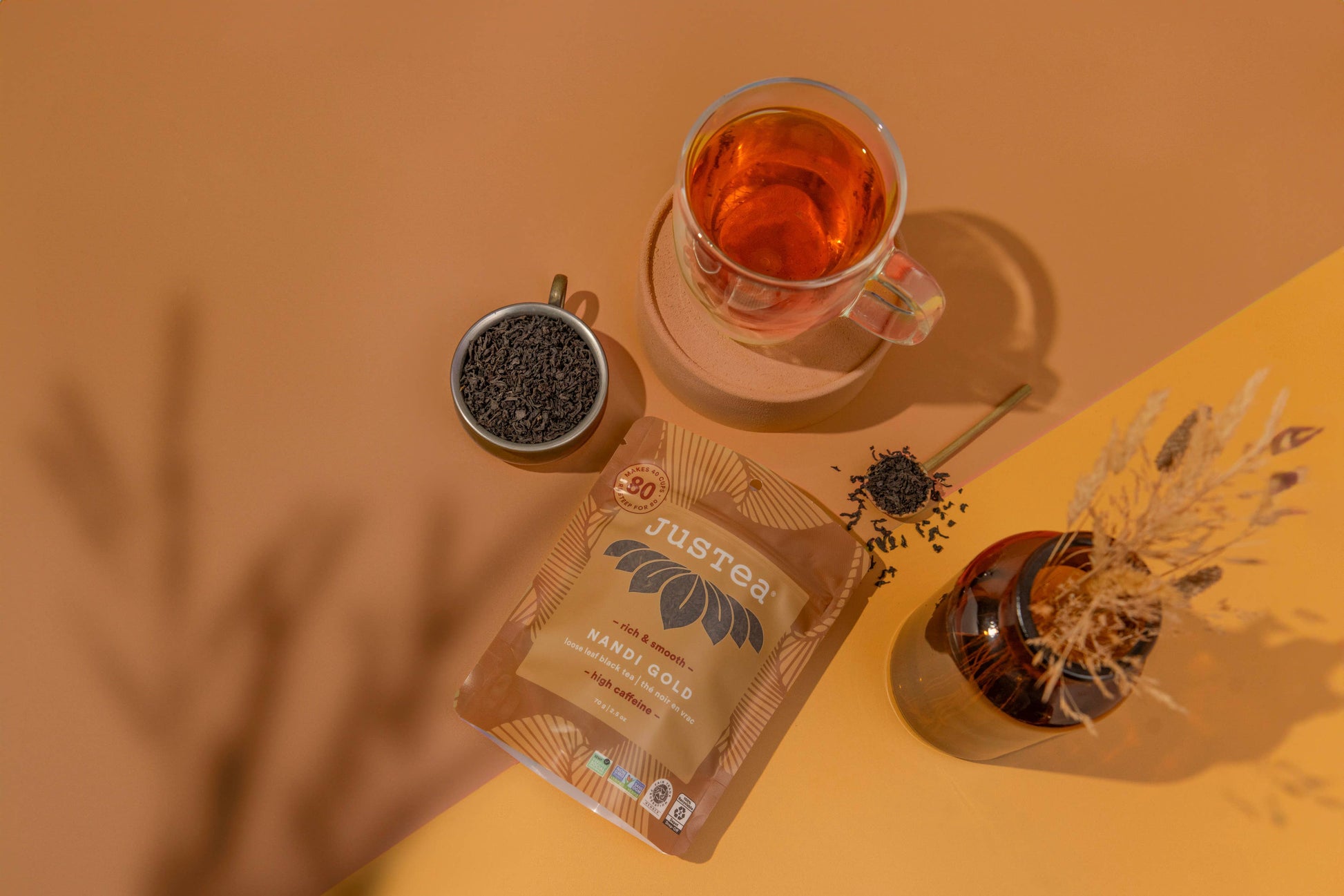 Tea packaging with a cup of tea, loose tea, and decorative elements on a warm-toned background