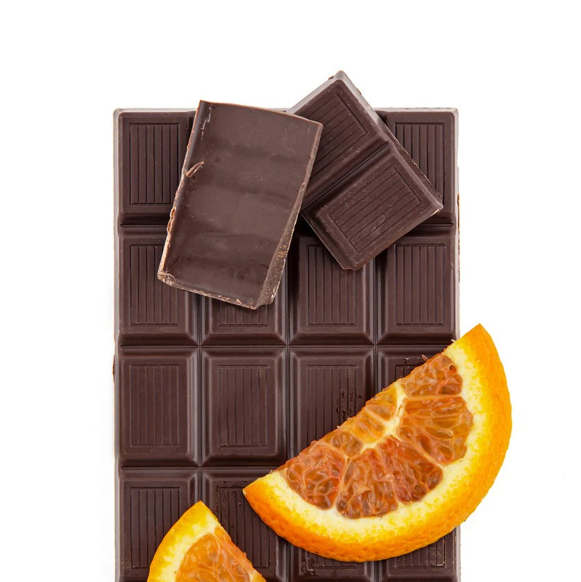 Dark chocolate bar with orange slices on a white background