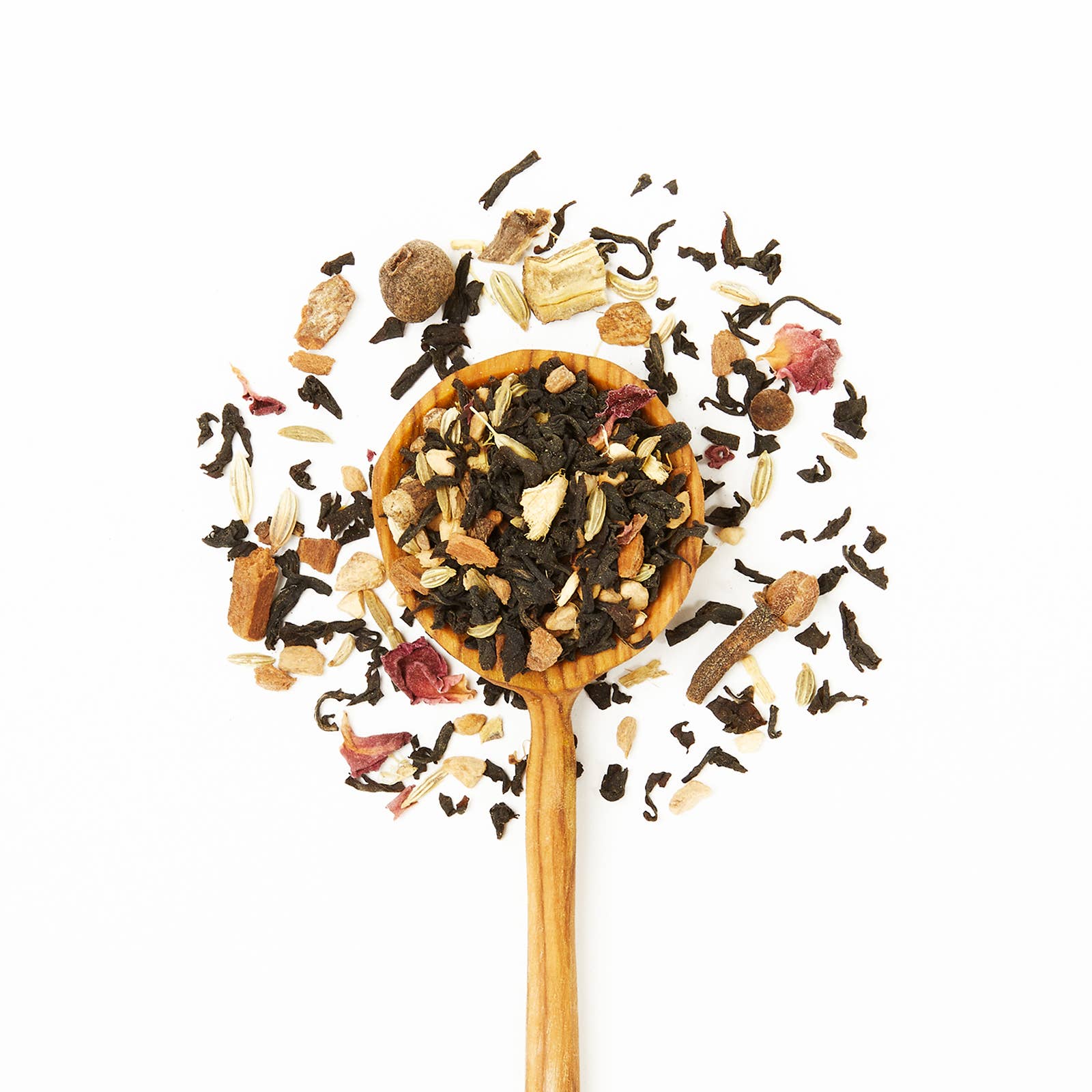 Wooden spoon filled with assorted dried tea leaves on a white background