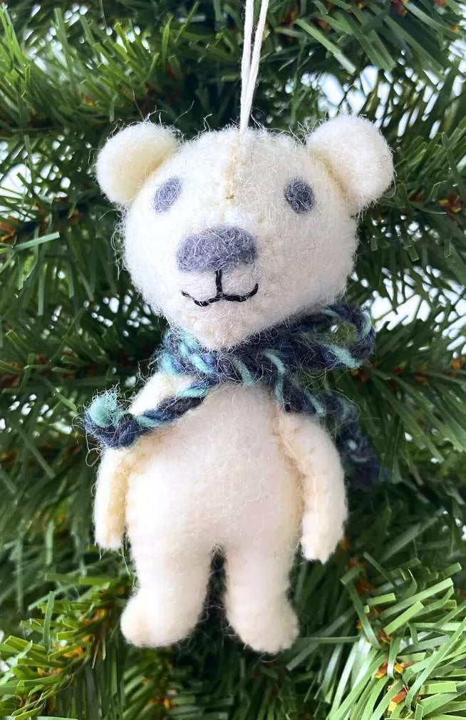 A felt bear ornament with a scarf, hanging on a Christmas tree.