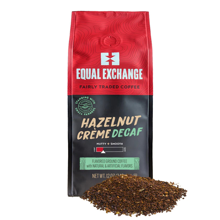 Red and black Equal Exchange hazelnut crème decaf coffee bag with ground coffee in front