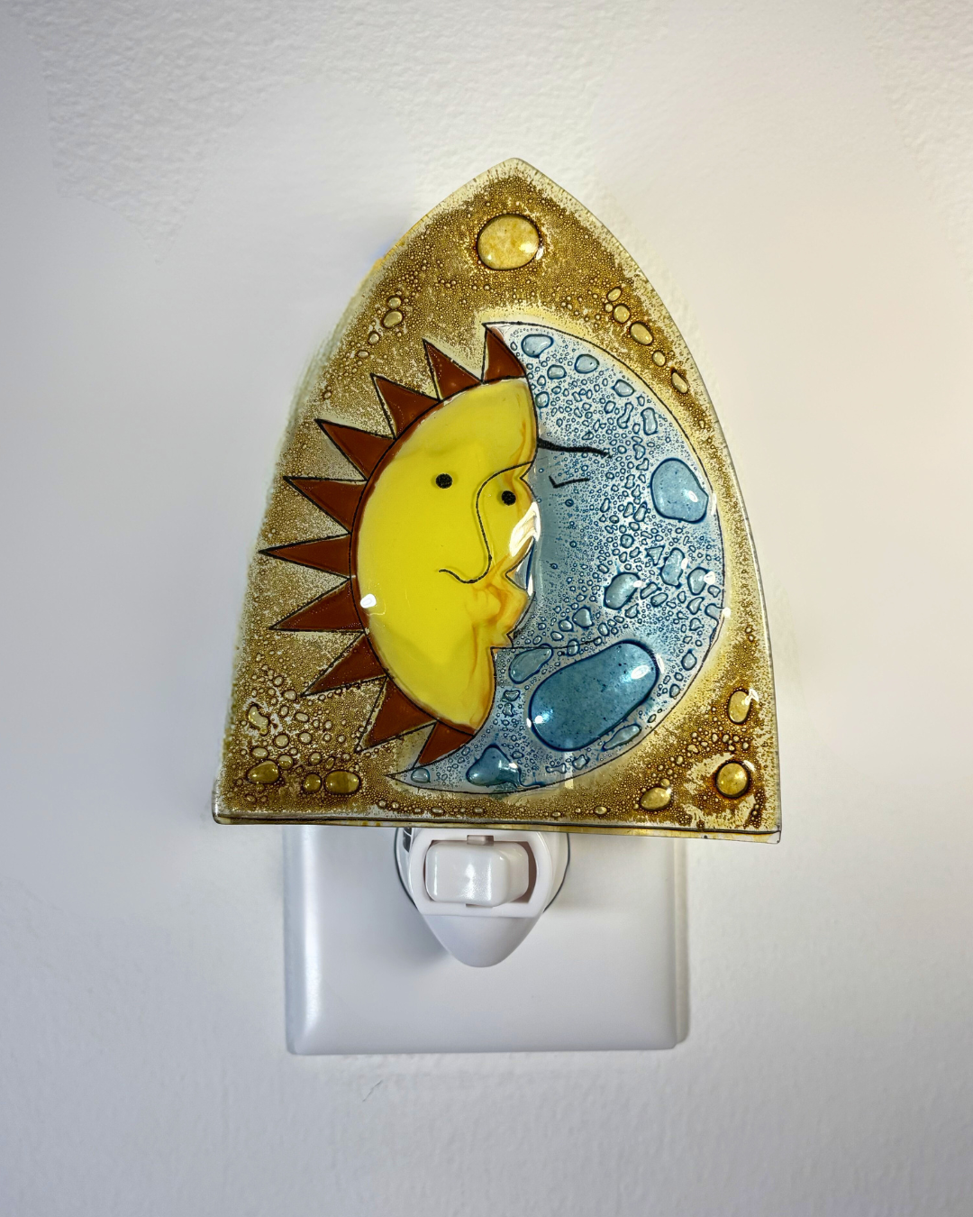 Decorative night light with a sun and moon design on a white background