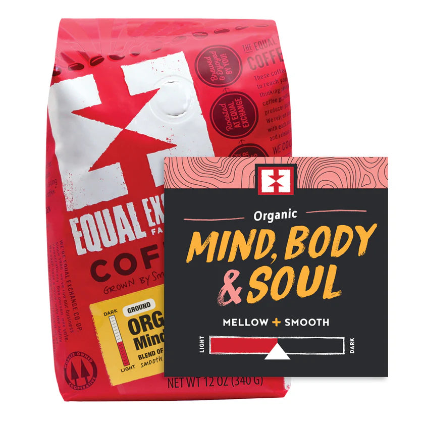 Two coffee packages, one red and one black of Mind, Body & Soul Equal Exchange coffee on a white background.