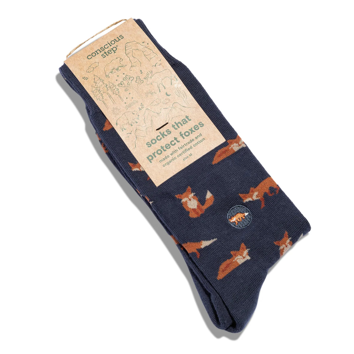 Navy socks with fox pattern on a white background in tan packaging with green type