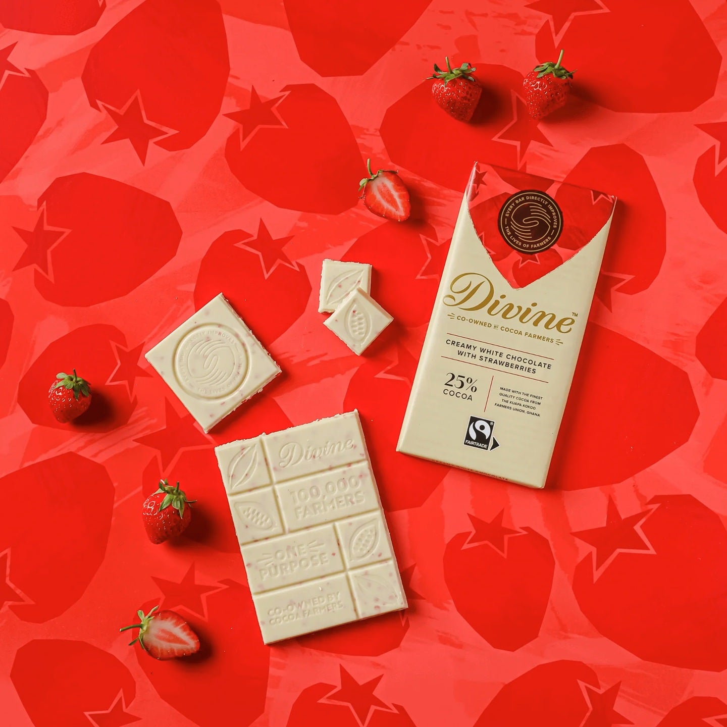 Divine White chocolate bars and packaging on a red background with strawberries